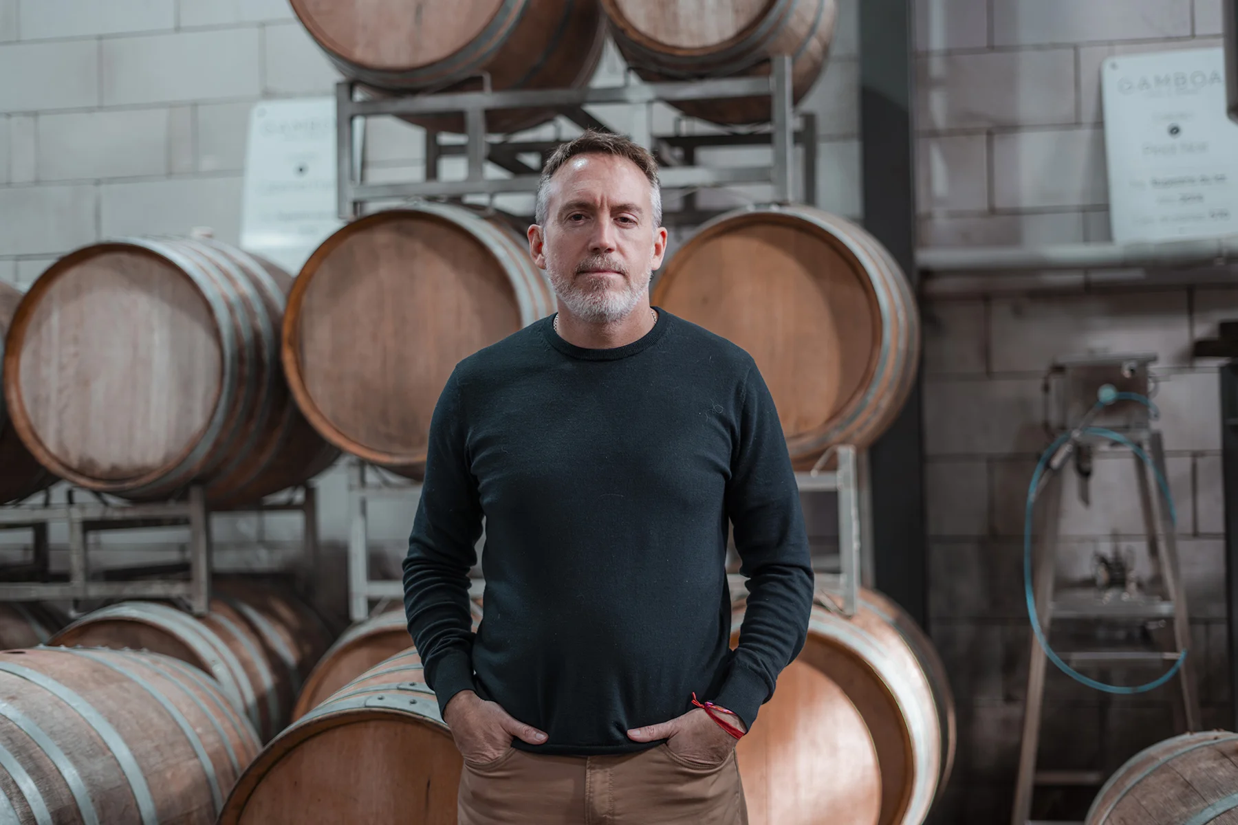 Eduardo Tuite en la bodega, frente a las barricas de roble